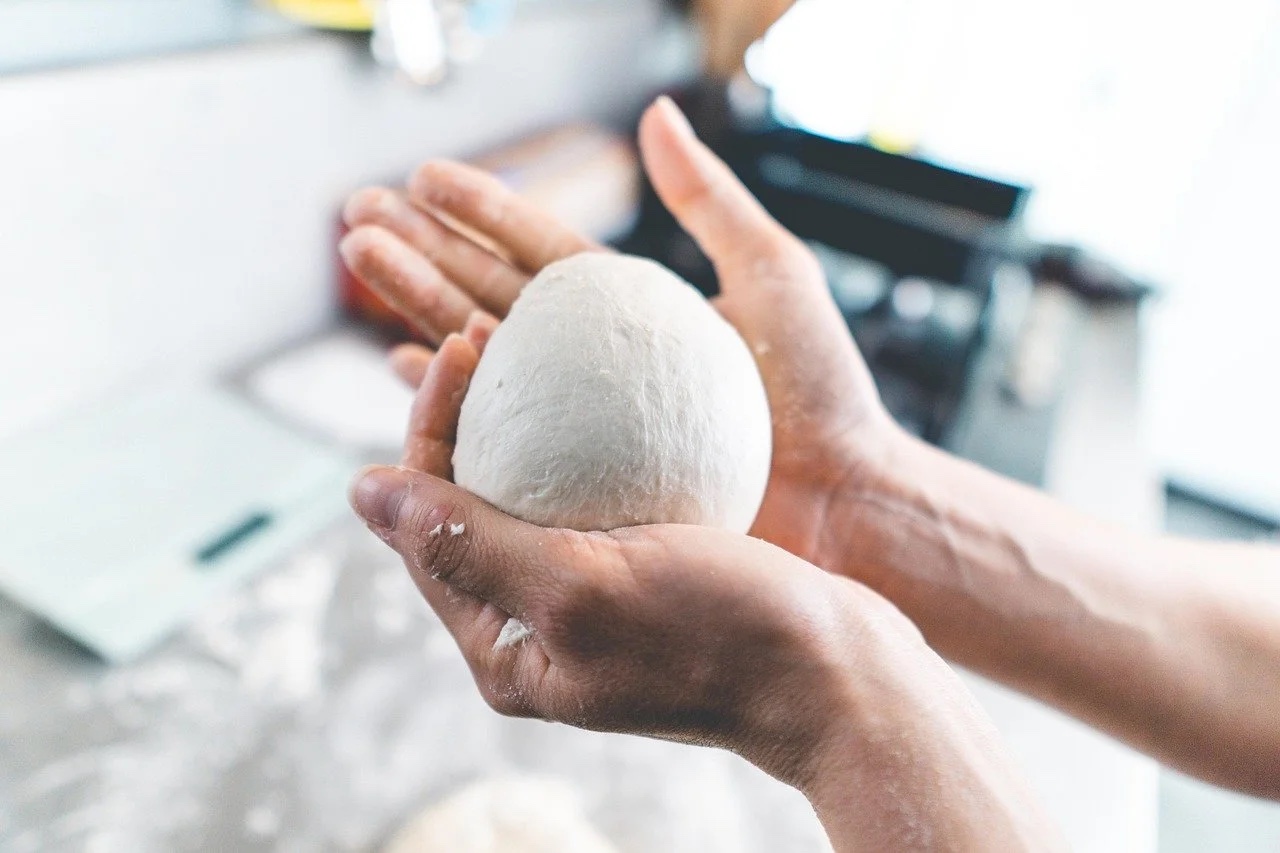 Hands shaping fresh cheese